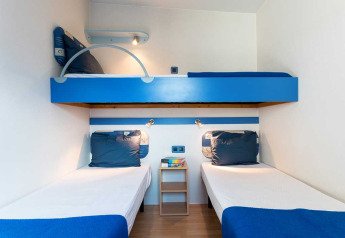 Moderne kamer in Baia Lux bij Baia Holiday Poljana, Kroatië, met stapelbed en twee eenpersoonsbedden.