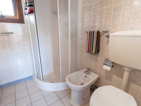 Salle de bain avec cabine de douche, bidet, toilettes et serviettes à Baia Lux, Baia Holiday Poljana, Croatie.