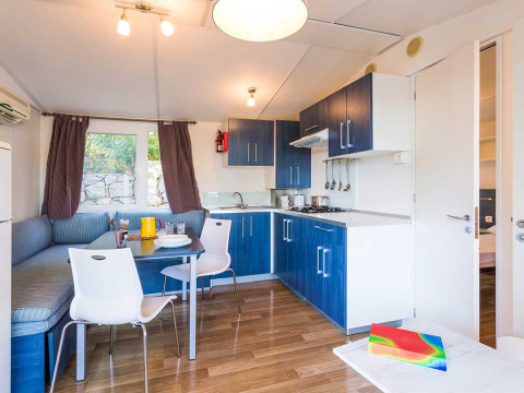 Cuisine et coin repas modernes avec armoires bleues et banquette d’angle à la Baia Superior en Croatie.