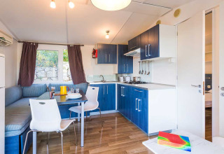 Cuisine et coin repas modernes avec armoires bleues et banquette d’angle à la Baia Superior en Croatie.