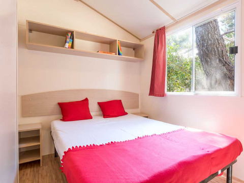 Bright bedroom at Blu Romantic lodge in Baia Holiday Poljana, Croatia, featuring red accents and large window.