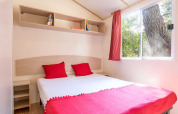 Camera luminosa al Blu Romantic lodge presso Baia Holiday Poljana in Croazia con dettagli rossi e finestra.