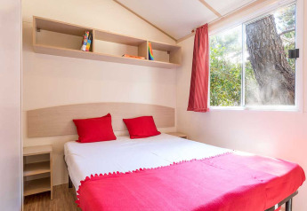 Camera luminosa al Blu Romantic lodge presso Baia Holiday Poljana in Croazia con dettagli rossi e finestra.