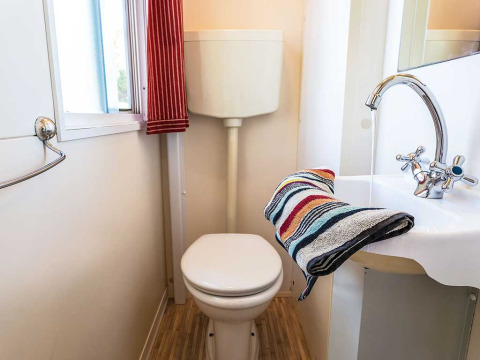 Compact bathroom at Blu Romantic lodge in Baia Holiday Poljana, Croatia, featuring toilet and sink.