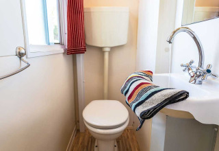 Compact bathroom at Blu Romantic lodge in Baia Holiday Poljana, Croatia, featuring toilet and sink.