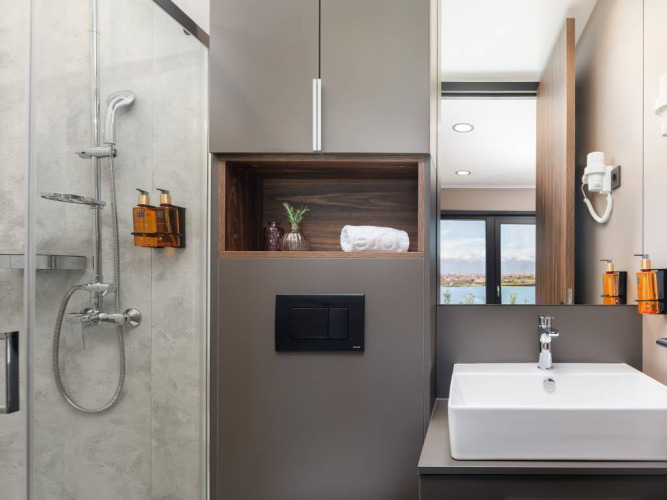 Bagno moderno con doccia, lavabo e mensole integrate presso Avalona Luxury Mare Glamping Villa in Croazia.