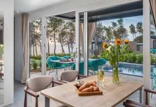 Eettafel met croissants, zonnebloemen en uitzicht op het zwembad en de zee bij Aminess Style Camping Avalona Resort, Kroatië.