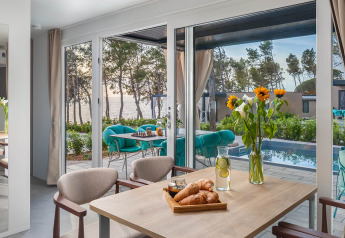 Esstisch mit Croissants, Blick auf Pool, Terrasse und Meer im Family Luxury Holiday Home Pool, Aminess Style Camping Avalona Resort.