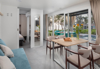 Modernes Ferienhaus mit Essbereich, Sofa und großen Fenstern mit Blick auf Pool und Meer in Kroatien.