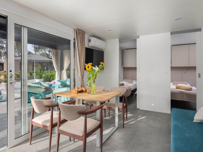 Casa vacanze familiare luminosa e moderna con zona pranzo, girasoli e terrazza all’Aminess Style Camping Avalona Resort.