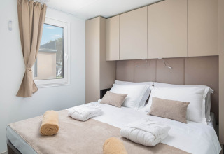 Modernes Schlafzimmer mit Doppelbett und beiger Einrichtung in der Family Luxury Holiday Home Pool in Kroatien.