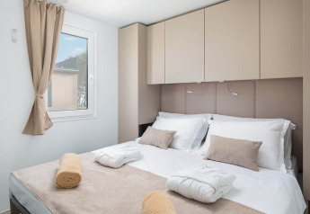 Modernes Schlafzimmer mit Doppelbett und beiger Einrichtung in der Family Luxury Holiday Home Pool in Kroatien.