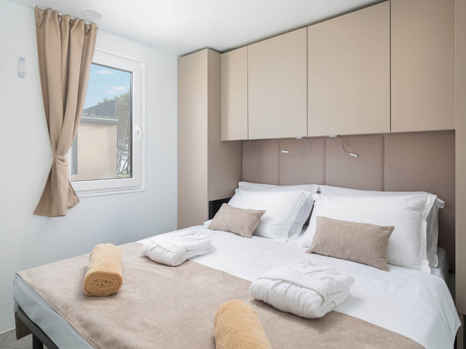 Camera da letto moderna e luminosa con letto matrimoniale e arredi beige al Family Luxury Holiday Home Pool in Croazia.