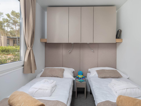Modernes Schlafzimmer mit zwei Einzelbetten, Schränken und Fenster in Aminess Style Camping Avalona Resort, Kroatien.