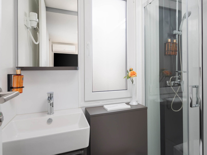 Bagno moderno con doccia, lavabo e finestra al Family Luxury Holiday Home Pool in Croazia.