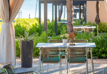 Tavolo all'aperto con sedie e vasi di fiori al Premium Holiday Home, Aminess Style Camping Avalona Resort, Croazia.