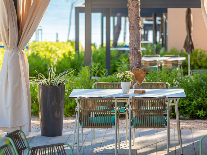 Tavolo all'aperto con sedie e vasi di fiori al Premium Holiday Home, Aminess Style Camping Avalona Resort, Croazia.