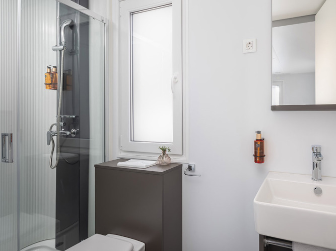 Bagno moderno con doccia, toilette, finestra e lavandino nel Premium Holiday Home, Croazia.
