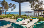 Buitenterras met zwembad, moderne stoelen en zeezicht aan een luxe vakantiewoning in Kroatië.