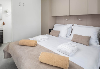 Camera da letto presso Luxury Holiday Home Pool ad Aminess Style Camping Avalona Resort in Croazia, con letto doppio e asciugamani puliti.