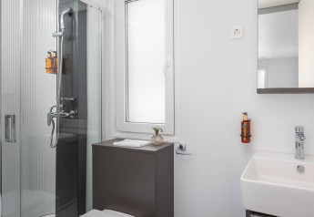 Bagno moderno con doccia, finestra, lavandino e specchio nello chalet di lusso a Aminess Style Camping Avalona Resort, Croazia.