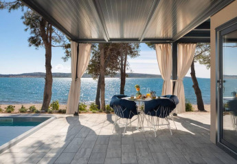 Terrasse med havudsigt, spisearrangement og pool ved stranden på Amber Sea Luxury Holiday Home i Kroatien.