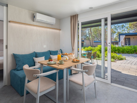 Moderne chalet eetruimte met terraszicht bij Family Premium Holiday Home in Aminess Style Camping Avalona Resort.