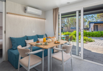 Moderna zona pranzo chalet con vista terrazza nel Family Premium Holiday Home ad Aminess Style Camping Avalona Resort.