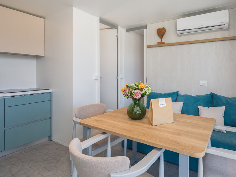 Zona pranzo nel Family Premium Holiday Home chalet di Aminess Style Camping Avalona Resort con arredo moderno.