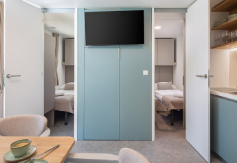 Chalet moderno con due camere da letto, cucina aperta, sala da pranzo e TV ad Aminess Style Camping Avalona, Croazia.