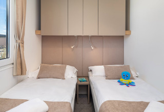 Camera da letto moderna con due letti singoli e arredi beige all'Aminess Style Camping Avalona Resort.
