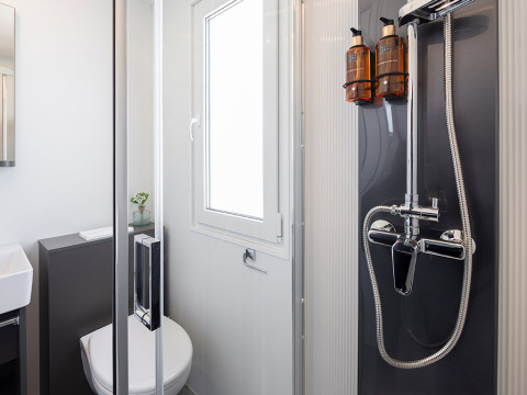Modernes Badezimmer mit Dusche, WC und Fenster im Family Premium Holiday Home im Aminess Style Camping Avalona, Kroatien.