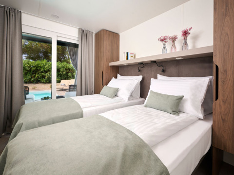 Moderne slaapkamer met twee aparte bedden en uitzicht op privézwembad bij Amber Sea Luxury Holiday Home Kroatië.