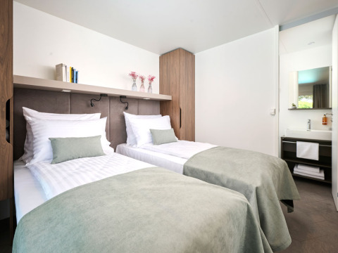Lichte slaapkamer met twee enkele bedden in Amber Sea Luxury Holiday Home bij Aminess Style Camping Atea Resort, Kroatië.