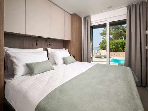 Moderne soveværelse på Amber Sea Luxury Holiday Home med udsigt til privat pool i Kroatien.