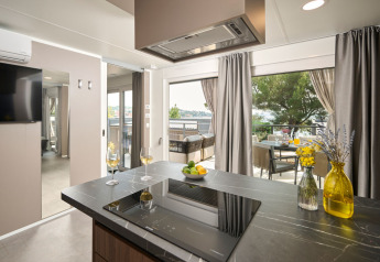 Moderne køkkenindretning med udsigt til terrasse og træer hos Amber Luxury Holiday Home, Aminess Style Camping Atea, Kroatien.