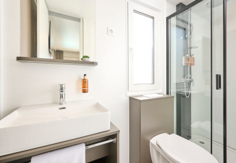 Moderne badeværelse med bruser, håndvask, spejl og toilet på Amber Luxury Holiday Home i Kroatien.