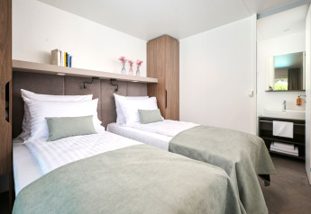 Moderne soveværelse med to enkeltsenge og lyse nuancer i Amber Luxury Holiday home, Aminess Style Camping Atea Resort, Kroatien.
