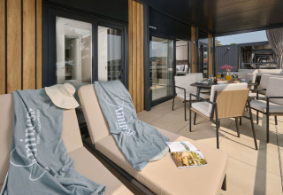 Terrazza soleggiata con lettini e tavolo da pranzo ad Amber Luxury Holiday Home, Aminess Style Camping Atea Resort, Croazia.