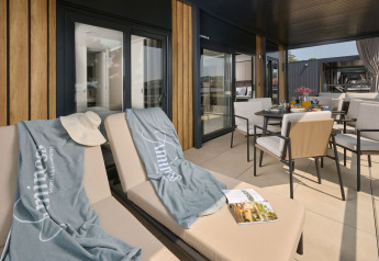 Solrig terrasse med liggestole og spisebord på Amber Luxury Holiday Home i Aminess Style Camping Atea Resort, Kroatien.