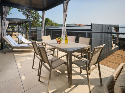 Buitenterras met eetset en ligstoelen bij Premium Holiday Home in Aminess Style Camping Atea Resort, Kroatië.