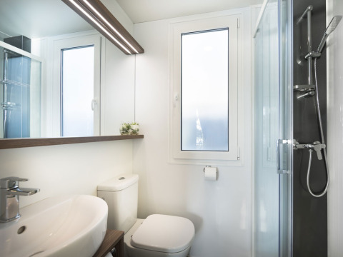 Moderne badkamer met douche, wc, lavabo en grote ramen in Comfort Holiday Home, Kroatië.