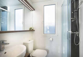 Moderne badeværelse med bruser, toilet, vask og store vinduer i Comfort Holiday home, Kroatien.