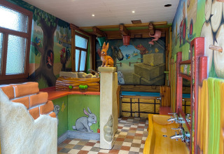 Bagno per bambini con disegni di animali e murales colorati presso Camping Fuussekaul, Wiltz, Lussemburgo.
