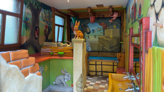 Kinderbadkamer met speelse dierenfiguren en kleurrijke muren in Camping Fuussekaul, Wiltz, Luxemburg.