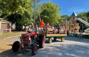 Bambini e adulti si godono un giro in trattore vicino al parco giochi del Camping Fuussekaul a Wiltz.