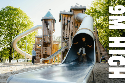 Children enjoying a 9-meter high playground slide at Camping Fuussekaul holiday park in Wiltz, Luxembourg.