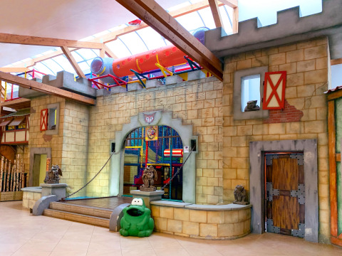 Indoor playground at Camping Fuussekaul in Wiltz, Luxembourg, featuring a castle design and tube slide.