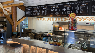 Snackbar in Camping Fuussekaul in Wiltz, Luxemburg met menuborden en Chupa Chups snoepjesdisplay.