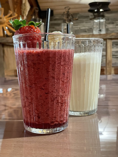 Due bicchieri con frullato e latte su un tavolo al Camping Fuussekaul a Wiltz, Lussemburgo, con fragola.